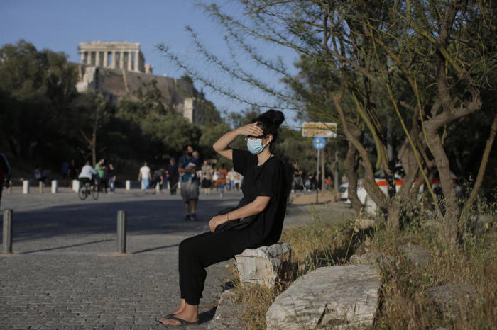 Ein Passant mit Gesichtsschutzmaske macht eine Pause auf dem Akropolis-Hügel in Athen, Griechenland. Foto: epa/Kostas Tsironis