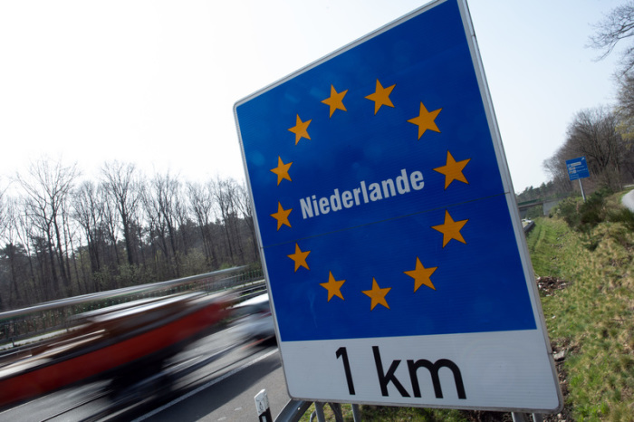Ein Schild weist an der Autobahn 52 auf den Grenzübergang zu den Niederlanden hin. Zahlreiche Deutsche nutzen die Osterfeiertage zu einem Abstecher in das Nachbarland. Foto: Federico Gambarini/dpa