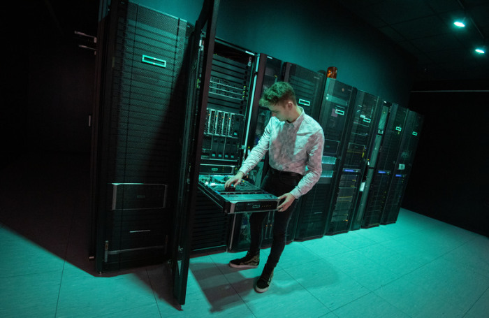 Ein Mitarbeiter des IT-Unternehmens Hewlett Packard Enterprise (HPE) demonstriert im Technologiezentrum des Unternehmens den Austausch eines Lüfters an einem Servers eines Rechnerraums. Foto: Marijan Murat/Dpa