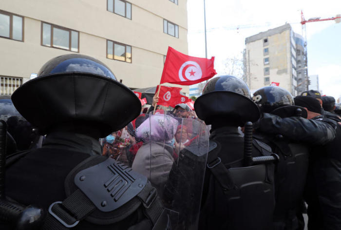 Die Polizisten stehen Wache vor den tunesischen Demonstranten. Foto: epa/Mohamed Messara