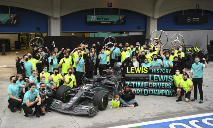 Lewis Hamilton, britischer Formel-1-Pilot von Mercedes-AMG Petronas (C), feiert mit seinem Hund und seinen Teammitgliedern. Foto: epa/Jeon Heon-kyun