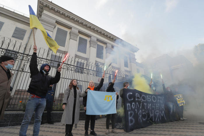Ukrainische Menschenrechtsaktivisten zünden während einer Kundgebung vor dem Gebäude der russischen Botschaft in Kiew Fackeln und Rauchgranaten. Foto: epa/Sergej Dolzhenko
