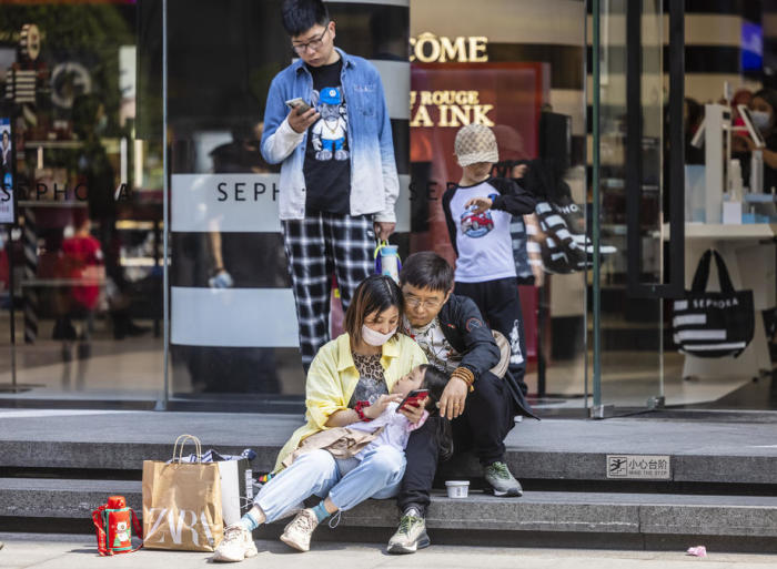 Journalisten ruhen sich in der Haupteinkaufszone von Shanghai aus. Foto: epa/Alex Plavevski