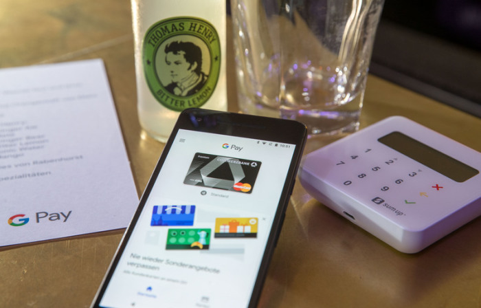 Ein Smartphone mit der App des neuen Bezahldienstes Google Pay liegt auf dem Tresen eines Cafés. Foto: Jens Büttner/Zb/dpa