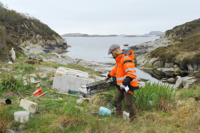 Eivind Bastesen untersucht Müll auf einer kleinen Insel vor der Stadt Bergen. Über Jahrzehnte hat die Strömung hier angeschwemmt, was Menschen achtlos weggeworfen haben. Foto: Sigrid Harms/Dpa