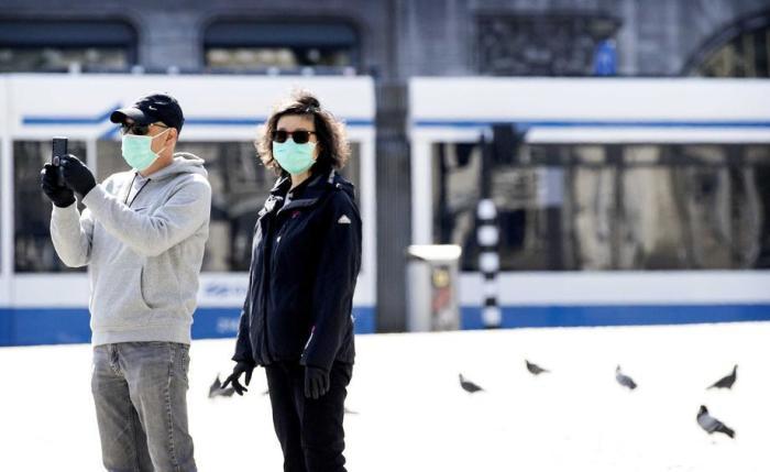 Eine Frau und ein Mann tragen in Amsterdam Gesichtsschutzmasken. Foto: epa/Koen Van Weel