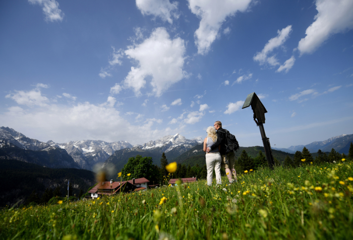 Zwei Urlauber aus Thüringen genießen am Eckbauer die Aussicht über das Wettersteingebirge. Foto: Angelika Warmuth/Dpa