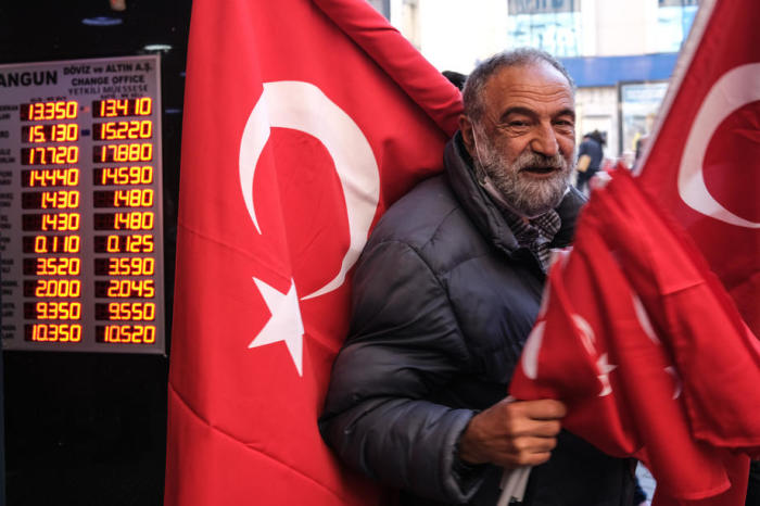 Ein Mann verkauft türkische Flaggen neben einer Wechselstube in Istanbul. Foto: epa/Sedat Suna