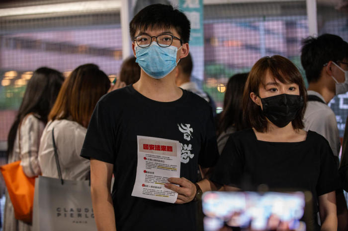 Der pro-demokratische Aktivist und Demosisto-Mitglied Joshua Wong (L), verteilt in Hongkong Flugblätter gegen Chinas umstrittenes nationales Sicherheitsgesetz für Hongkong. Foto: epa/Jerome Favre