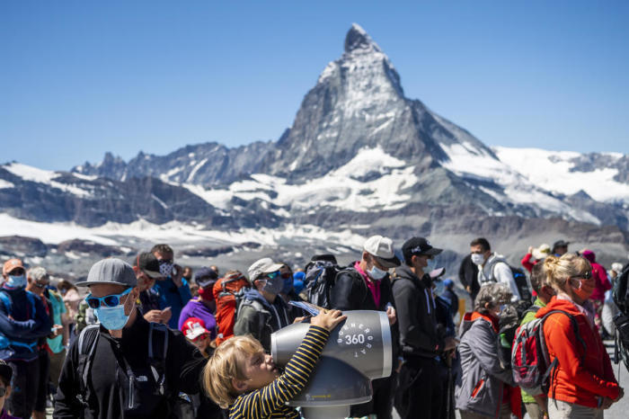 Schutzmasken tragende Touristen stehen in der Schlange vor dem Zug der Gornergrat Bahn vor dem Matterhorn. Archivfoto: epa/JJEAN-CHRISTOPHE BOTT