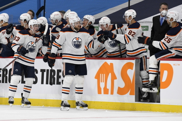 NHL, Winnipeg Jets - Edmonton Oilers, Hauptrunde, North Division, 104. Spieltag. Leon Draisaitl (M) von den Edmonton Oilers feiert sein Tor mit den Teamkollegen auf der Bank. Foto: Fred Greenslade/The Canadian Press/dpa