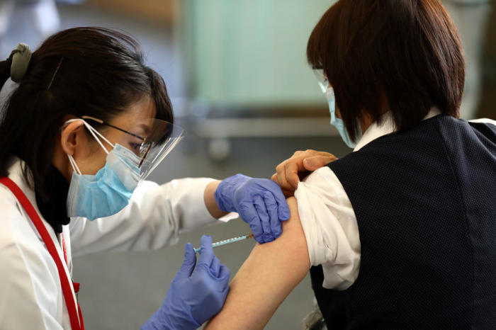 Ein Gesundheitshelfer (R) erhält eine Dosis des COVID-19-Impfstoffs, als das Land seine Impfkampagne startet, in Tokio. Foto: epa/Behrouz Mehri