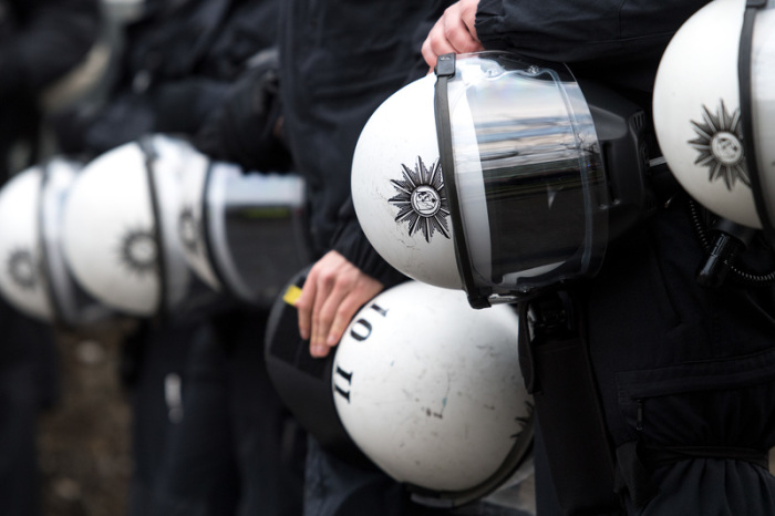Polizisten halten während einer Demonstration ihre Schutzhelme unter dem Arm. Foto: Marius Becker/Dpa