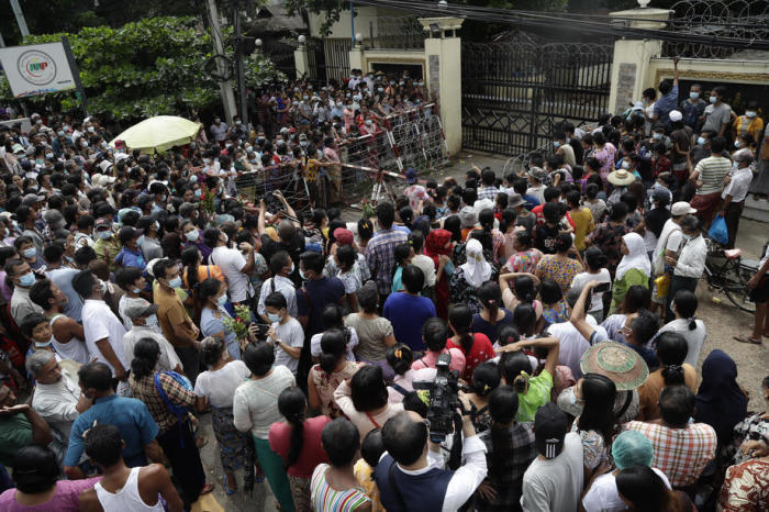 Menschen warten hinter Barrikaden auf die Freilassung ihrer Angehörigen vor dem Haupteingang des Insein-Gefängnisgeländes in Yangon. Foto: epa/Lynn Bo Bo