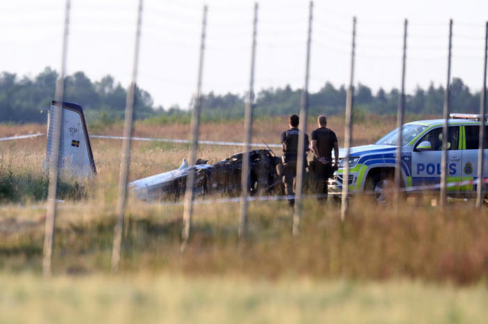 Offiziere stehen neben dem Wrack des abgestürzten Flugzeugs am Flughafen Orebro. Foto: epa/Jeppe Gustafsson