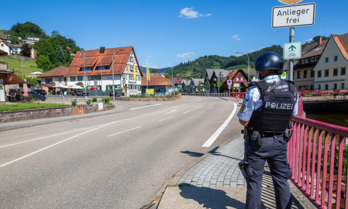 Ein Polizist sichert eine Straße im Ortskern. Ein Großaufgebot der Polizei sucht seit dem Vormittag einen bewaffneten Mann. Ein mit Pfeilen und Bogen Bewaffneter hatte in dem Ort im Schwarzwald Polizisten bedroht... Foto: Philipp von Ditfurth/dpa