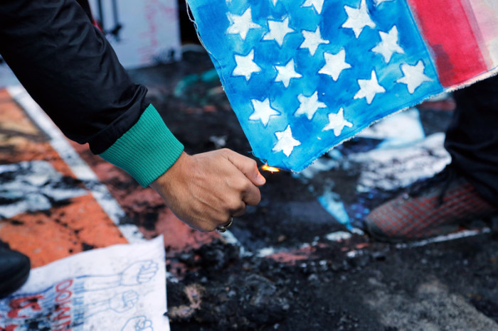  Demonstrant setzt die US-Flagge in Brand. Foto: epa/Abedin Taherkenareh
