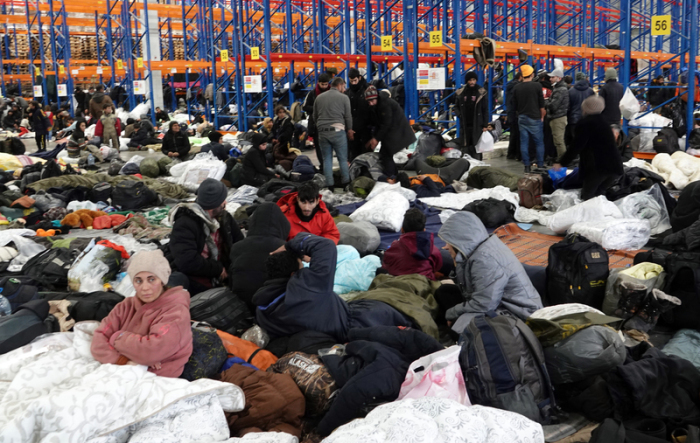 Migranten sind in der Notunterkunft in der Lagerhalle eines Logistikzentrums nahe der Grenze zu Polen. Foto: Ulf Mauder/dpa