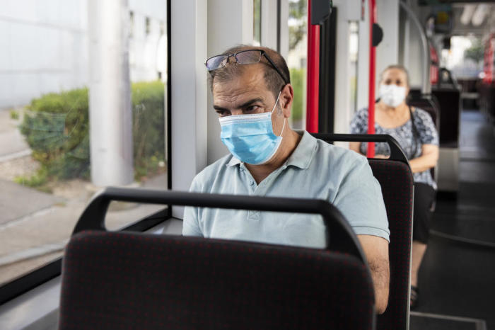 Fahrgäste mit Schutzmasken sitzen in einem Tram in Bern. Foto: epa/Peter Klaunzer