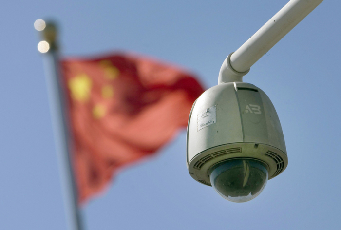 Eine Überwachungs-Kamera ist auf dem Tiananmen-Platz vor einer chinesischen Nationalflagge installiert. Foto: epa Diego Azubel/Epa/dpa