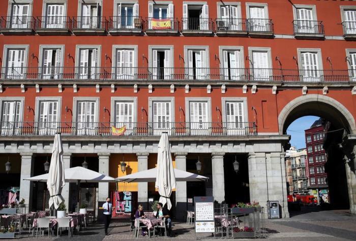 Die Menschen sitzen auf einer Bar-Terrasse auf der Plaza Mayor in der Innenstadt von Madrid. Foto: epa/David Fernandez