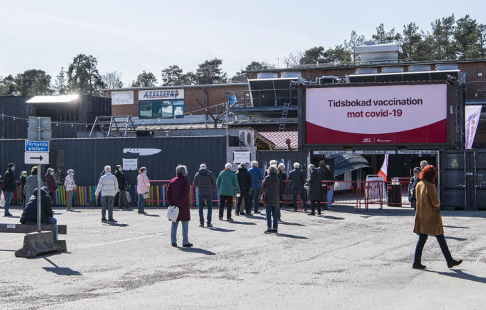 Vor einem Nachtclub, der zu einem Massenimpfzentrum in Stockholm umfunktioniert wurde, stehen Menschen Schlange, um sich gegen das Coronavirus Covid-19 impfen zu lassen. Foto: epa/Carl-olof Zimmerman