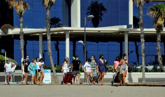 Leute, die Gesichtsmasken tragen, sind auf dem Weg zum Strand La Patacona in der Küstenstadt Alboraia, Ostspanien. Foto: epa/Manuel Bruque