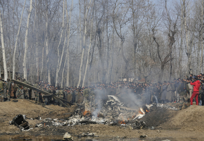 Kaschmirische Dorfbewohner versammeln sich in der Nähe eines Wracks von einem indischen Kampfflugzeuge. Foto: Mukhtar Khan/AP/dpa