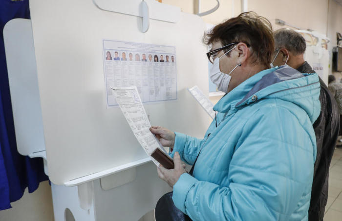 Wähler prüfen während der Moskauer Kommunalwahlen am Tag der Einheitswahl in Moskau die Liste der Kandidaten in einem Wahllokal. Foto: epa/Sergei Ilnitsky