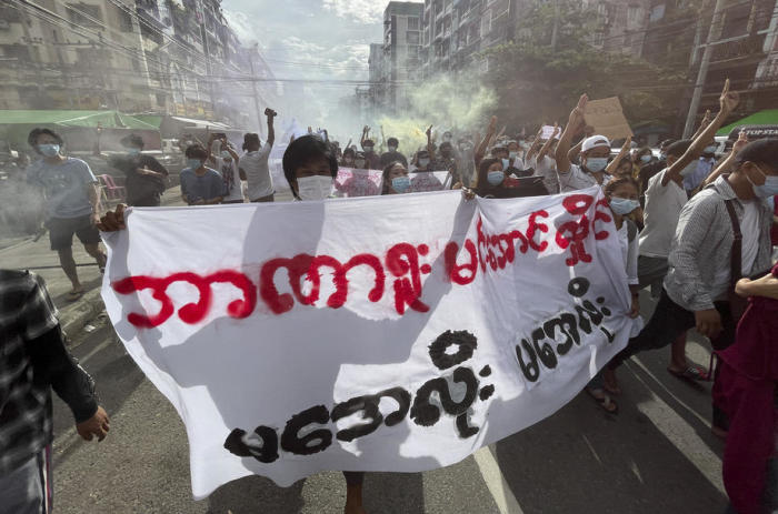 Demonstranten halten Plakate und Fackeln, während sie während einer Anti-Militärputsch-Demonstration in der Innenstadt von Yangon marschieren. Foto: epa/Stringer