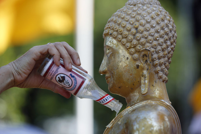 Das vorsichtige Begießen der Buddha-Statuen mit geweihtem Wasser ist eine der traditionellen Riten der Songkran-Feierlichkeiten. Foto: epa/Rungroj Yongrit