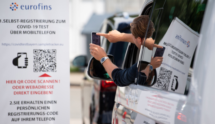 Ein Mann scannt mit seinem Smartphone an einem Corona-Testzentrum an der Autobahn 93 (A93) an der Rastanlage Inntal-Ost einen QR-Code, mit dessen Hilfe man sich für den Test anmelden kann. Foto: Sven Hoppe/dpa
