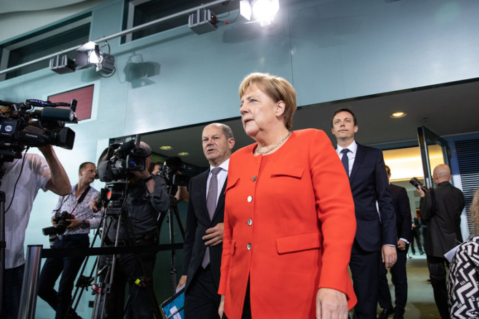 Finanzminister Olaf Scholz (l.), Bundeskanzlerin Angela Merkel (M.) und der saarländische Ministerpräsident Tobias Hans (r.). Foto: epa/ Omer Messinger