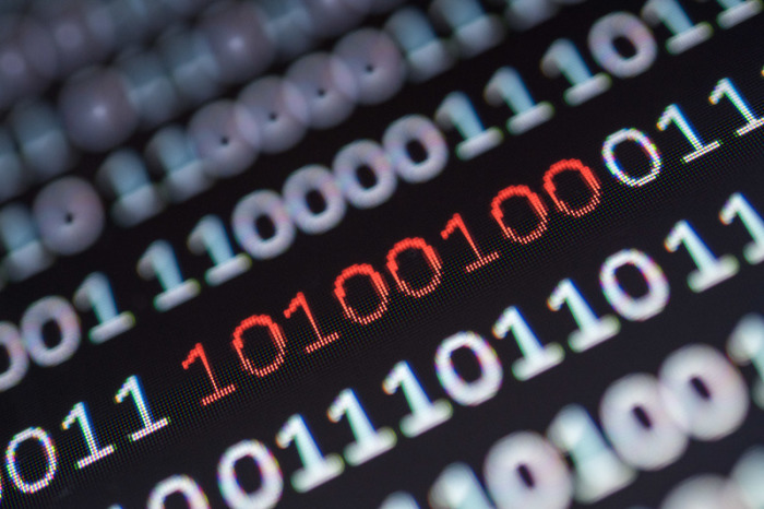 Binärcode, von dem ein Segment rot eingefärbt ist, steht auf einem Bildschirm. Die Cyberkriminalität nimmt zu.. Foto: Sebastian Gollnow/Dpa