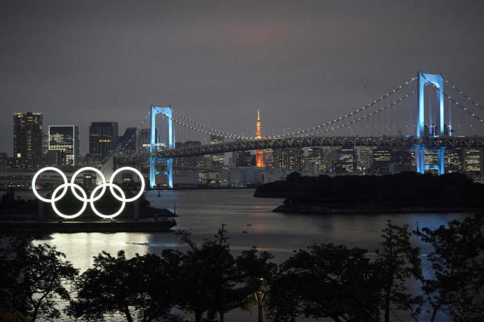 Riesiges Denkmal der Olympischen Ringe vor der Regenbogenbrücke in Tokio beleuchtet. Foto: epa/Franck Robichon