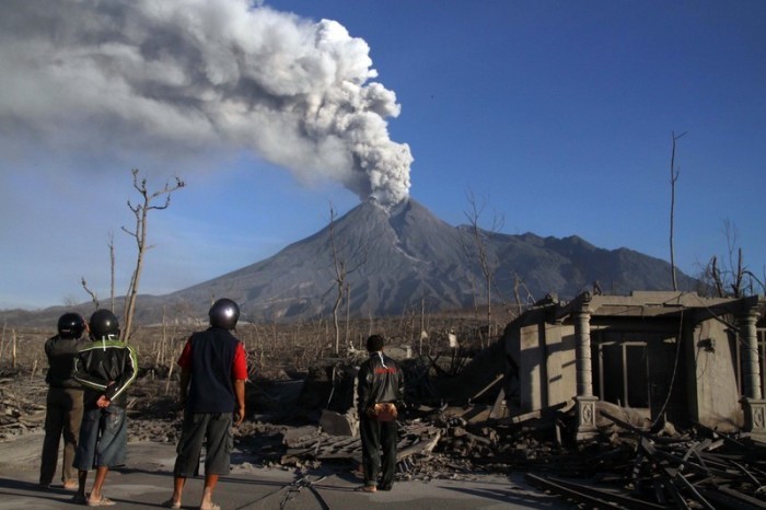 Indonesische Männer betrachten den Ausbruch des Berges Merapi im Dorf Bimomartani, Sleman. Foto: epa/Hadi Susanto