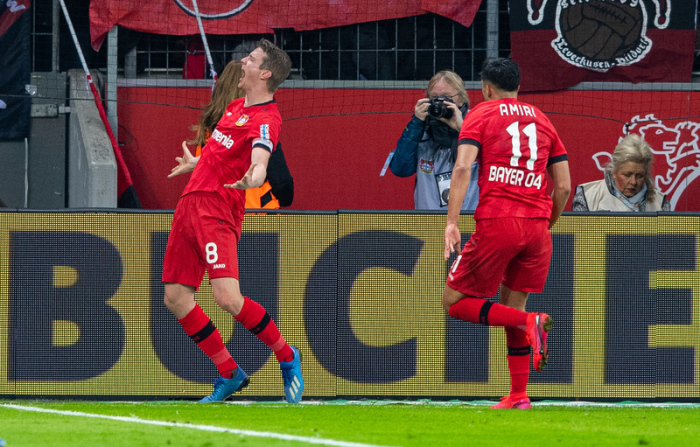 Leverkusens Torschütze Lars Bender (l-r) bejubelt sein Tor zum 4:3 mit Leverkusens Nadiem Amiri. Foto: Guido Kirchner/Dpa