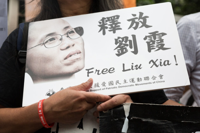 Chinesische Aktivisten halten ein Foto von Liu Xia hoch. Foto: epa/efe/Jerome Favre