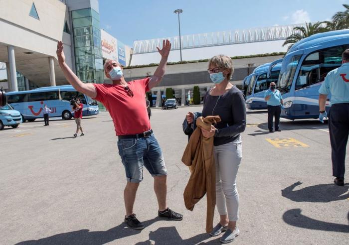 Deutsche Touristen tragen bei ihrer Ankunft auf dem Flughafen von Palma de Mallorca Gesichtsmasken. Foto: epa/ATIENZA