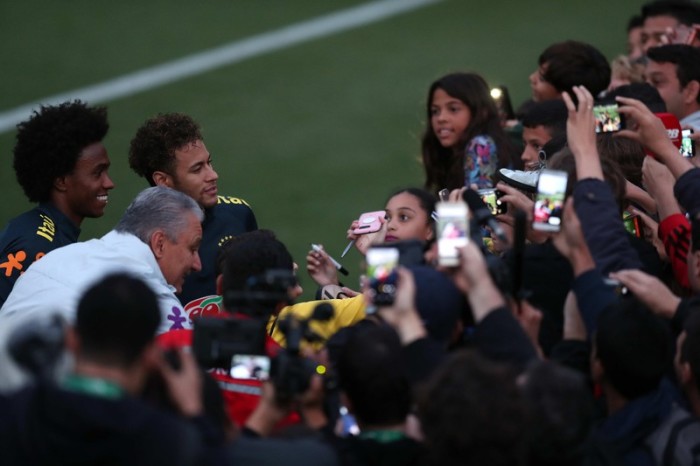Der brasilianische Nationaltrainer Tite und der Spieler Neymar Jr begrüßen die Fans nach einem Training im Granja Comary Center in Teresopolis. Foto: epa/Marcelo Sayao
