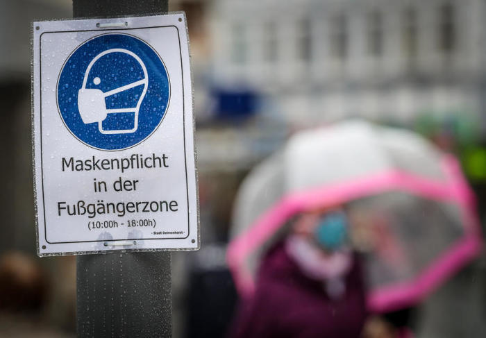 Auf einem Schild im Stadtzentrum von Delmenhorst, Norddeutschland, steht 'Gesichtsmasken in der Fußgängerzone obligatorisch'. Foto: epa/Focke Strangmann