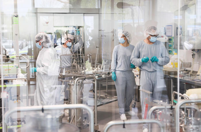 Die Mitarbeiter arbeiten bei der Produktion des Comirnaty-Impfstoffs von Biontech/Pfizer in den Produktionsanlagen von Allergopharma. Foto: epa/Christian Charisius