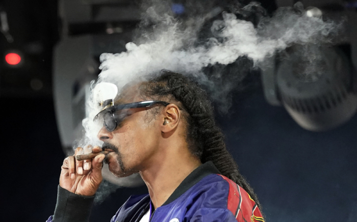 Snoop Dogg, US-Rapper, raucht auf der Bühne während seines DJ-Set als «DJ Snoopadelic». Foto: Chris Pizzello/Invision/ap/dpa