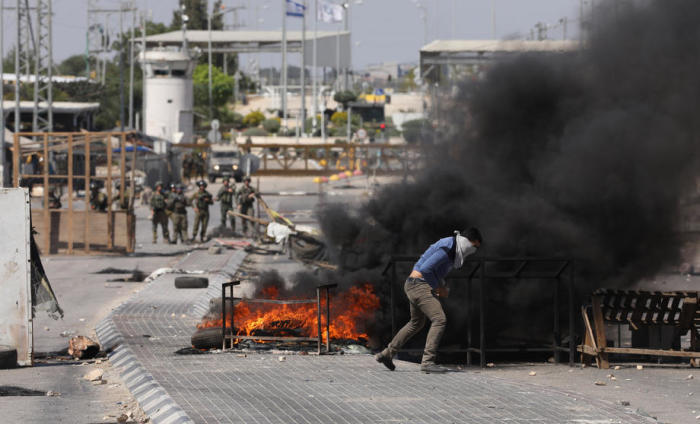 Eine palästinensische Demonstrantin schleudert Steine während Zusammenstößen mit israelischen Truppen am Al Jalamah Checkpoint nahe der Westbank-Stadt Jenin. Foto: epa/Alaa Badarneh