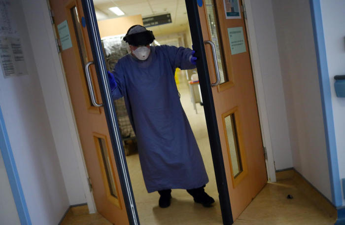Ein medizinischer Mitarbeiter öffnet erschöpft die Türen zur Intensivstation des Royal Blackburn Teaching Hospital in East Lancashire. Foto: epa/Hannah Mckay