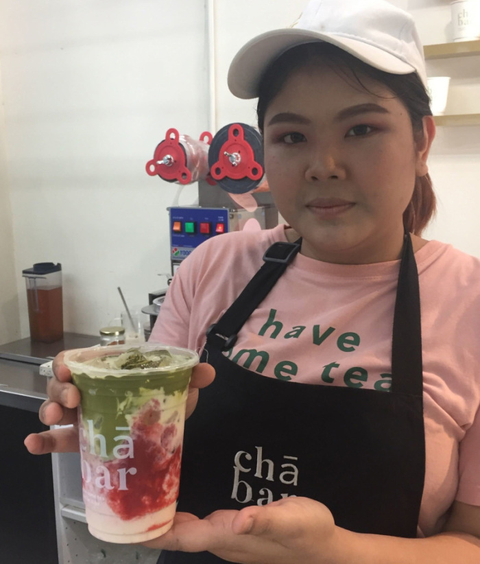 Eine Verkäuferin reicht einen frisch gemixten Shake mit dem Geschmack von grünem Tee und Erdbeere. Fotos: picture alliance/Caroline Bock/dpa