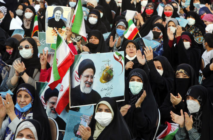 Unterstützerinnen des iranischen Präsidentschaftskandidaten Ebrahim Raisi halten Bilder, die ihn zeigen, während einer Wahlkampfkundgebung in Teheran. Foto: epa/Abedin Taherkenareh