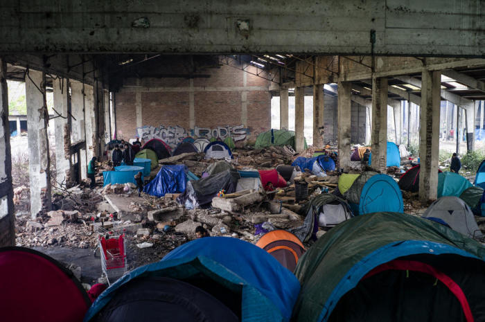 Flüchtlinge versammeln sich in dem behelfsmäßigen Migrantenlager in Grande-Synthe in der Nähe von Dunkerque. Foto: epa/Yoan Valat