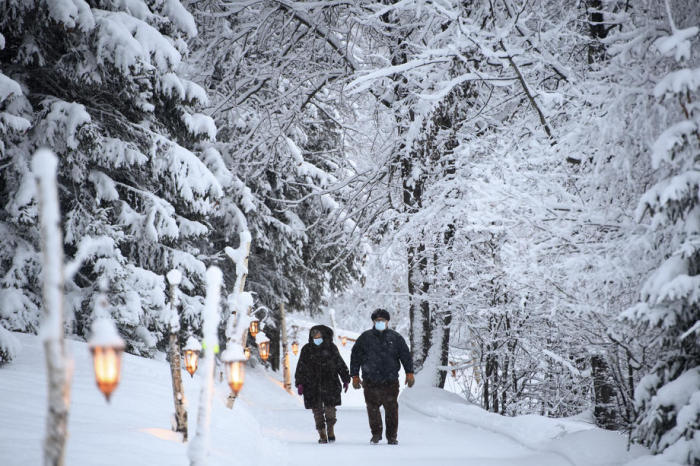 Leute laufen den zwei Kilometer langen, schneebedeckten Laternenpfad. Foto: epa/Laurent Gillieron
