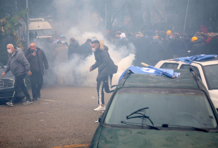 Demonstranten gehen in Deckung, als die Polizei bei einer Demonstration vor dem Gebäude der Demokratischen Partei in Tirana Tränengas einsetzt. Foto: epa/Malton Dibra